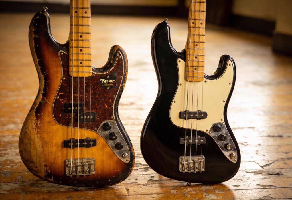 Zwei E-Bässe, einer mit Vintage-Look und der andere in schwarz.