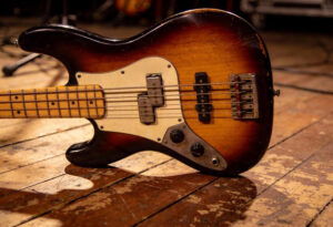 Vintage Fender Precision Bass E-Bass mit Sunburst-Finish auf Holzboden, Detailansicht von Korpus, Pickups und Steg