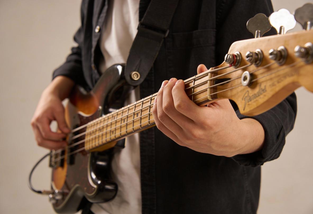 Ein Musiker spielt eine Bassgitarre mit beiden Händen.