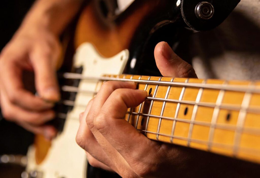 Nahaufnahme eines Bassisten, der auf einem Bassgitarre spielt