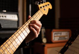 Eine Hand spielt eine Bassgitarre in einem Studio.