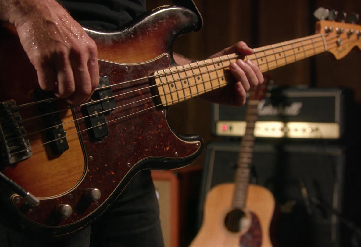 Nahaufnahme eines Bassisten, der einen Bass spielt.