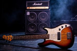 Elegante elektrische Bassgitarre liegt vor einem Marshall-Verstärker