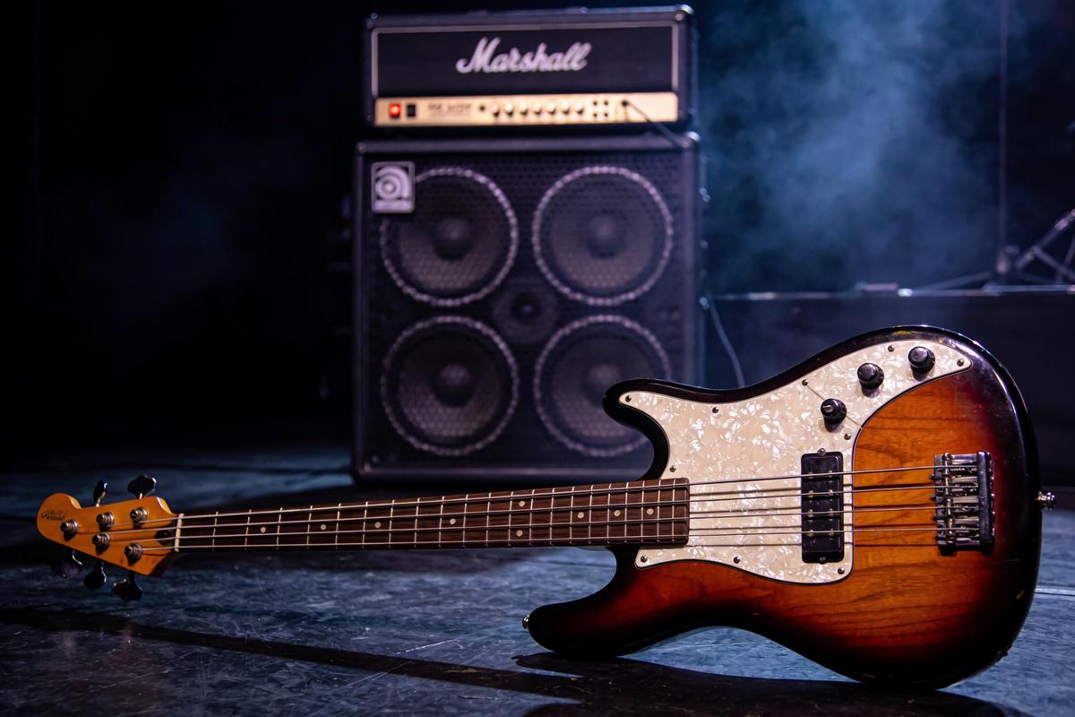 Elegante elektrische Bassgitarre liegt vor einem Marshall-Verstärker