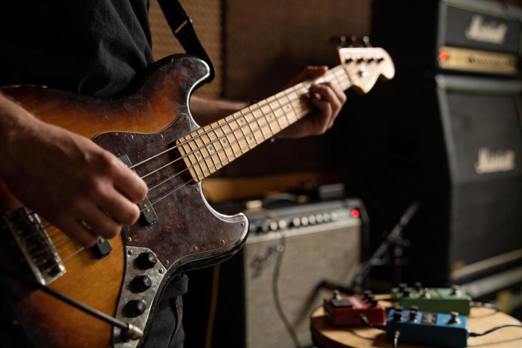 Ein Bassist spielt einen E-Bass in einem Studio.