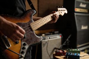 Ein Bassist spielt einen E-Bass in einem Studio.