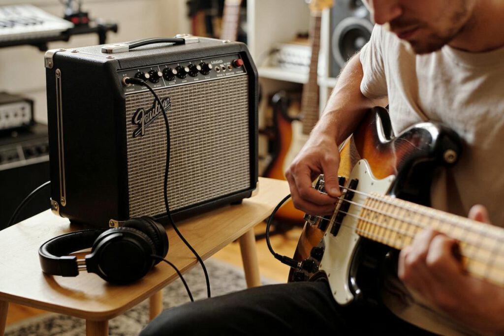 Ein Bassist spielt auf einem E-Bass neben einem Verstärker