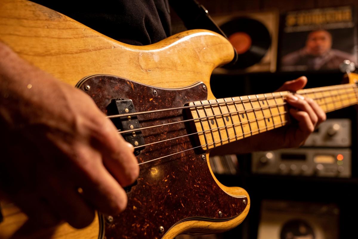 Nahaufnahme eines Bassisten, der einen E-Bass spielt.
