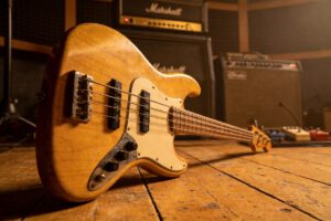 Nahaufnahme einer Vintage Bassgitarre auf Holzboden im Studio