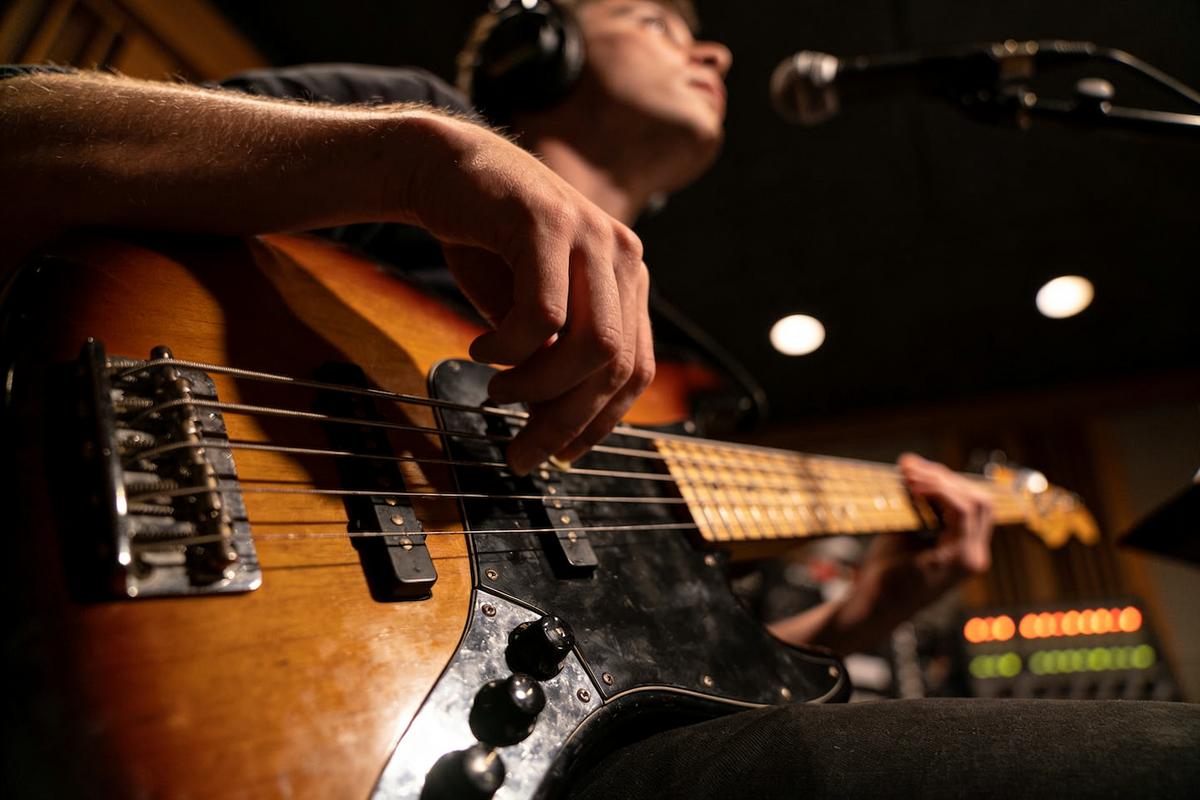 Ein Bassspieler spielt E-Bass im Studio.