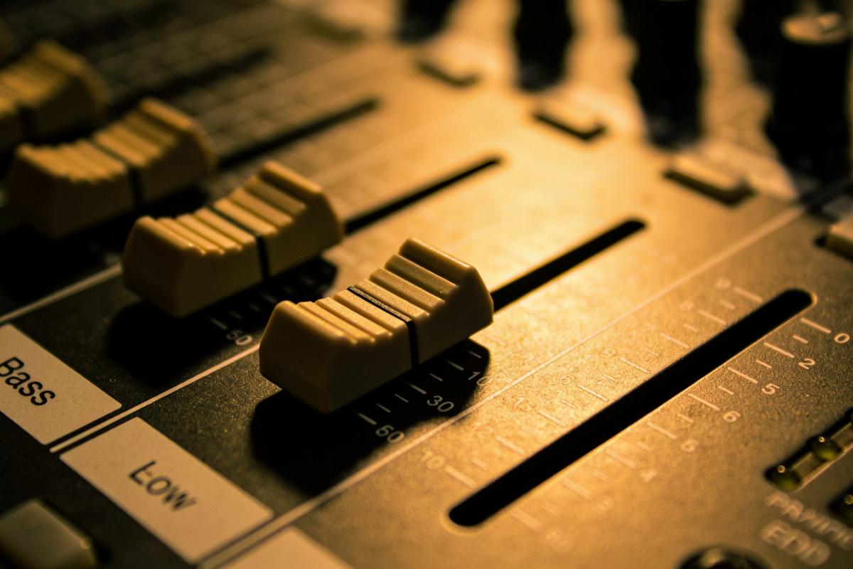 Nahaufnahme eines Mischpults mit Fokus auf den Bass-Fader