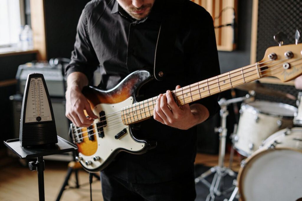 Ein Bassist spielt eine E-Bassgitarre in einem Studio.