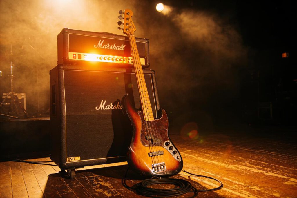 Ein E-Bass steht neben einem Marshall-Verstärker auf der Bühne.