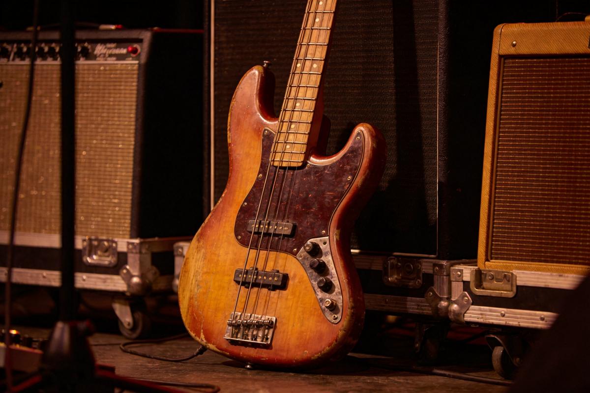 Ein Vintage E-Bass steht neben Verstärkern auf der Bühne