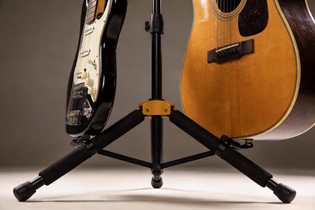 Ein schwarzer Gitarrenständer hält eine E-Gitarre und eine Akustikgitarre sicher.