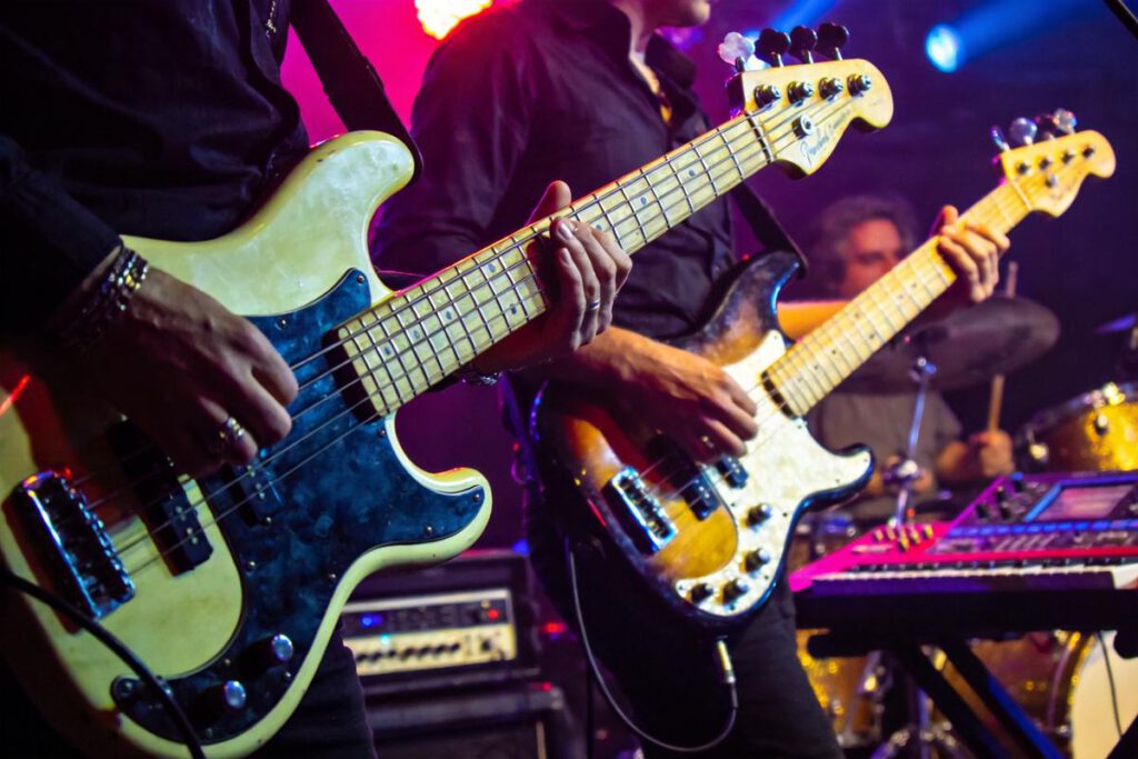 Zwei Musiker spielen Live-Bassgitarren auf der Bühne.